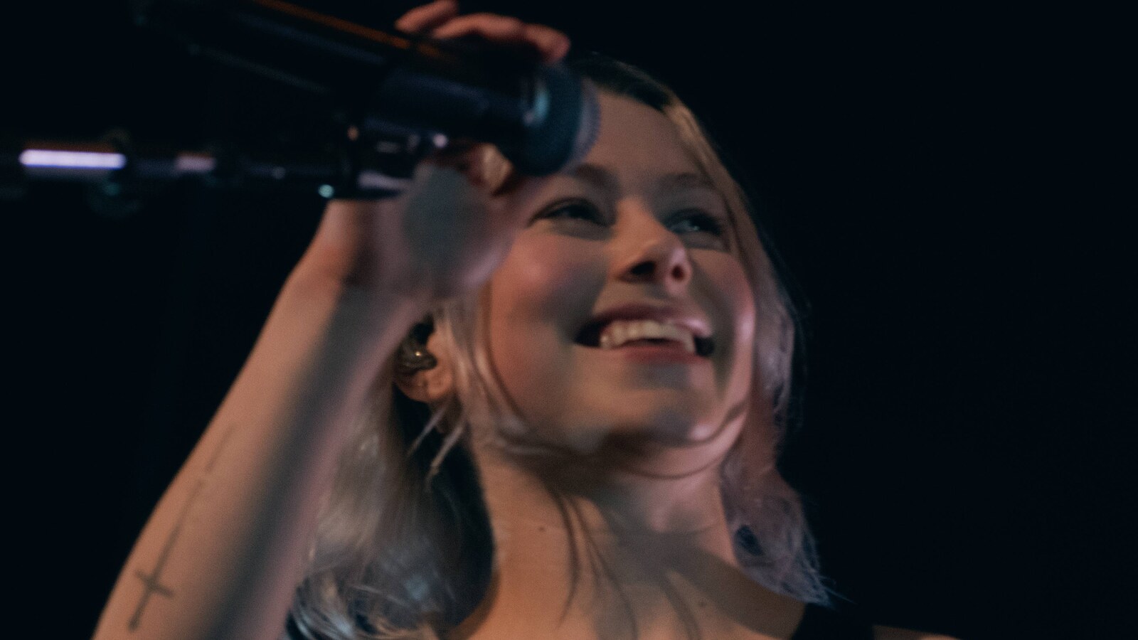Phoebe Bridgers se apresentando ao vivo com um microfone